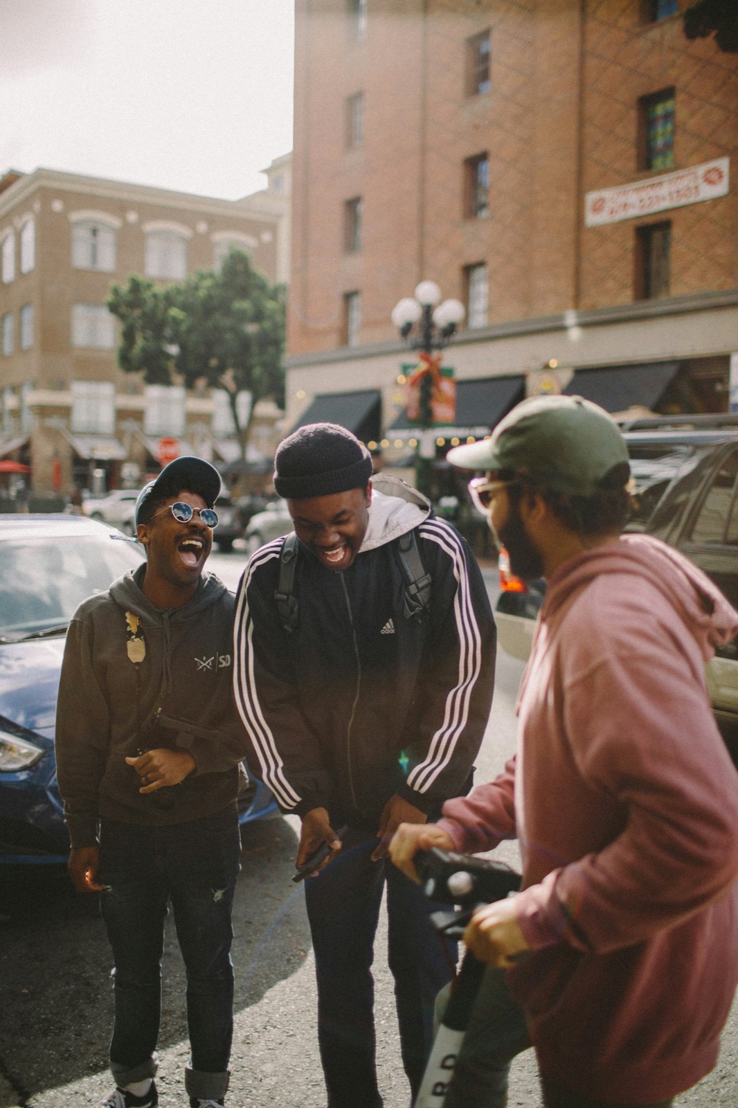 Three friends laughing together outdoors